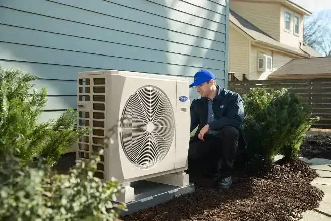 HVAC installer inspecting a newly positioned outdoor cooling system