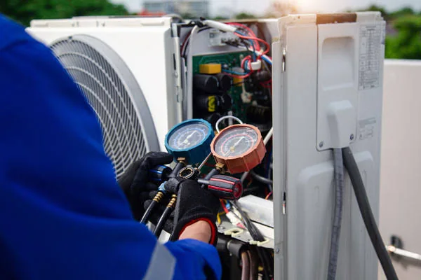 Technician checking refrigerant pressure during AC repair