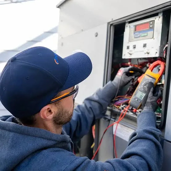 Technician using an electrical meter to troubleshoot HVAC controls